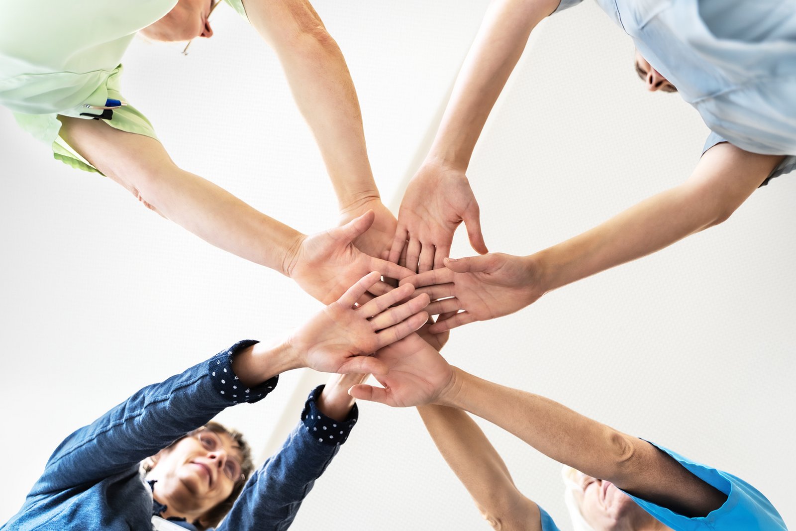 Zusammengelegte Hände, die das interdisziplinäre Teamwork zeigen