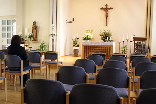 Krankenhauskapelle mit Stühlen, Altar und Kreuz